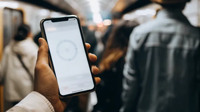 Smartphone user waiting impatiently as a website loads slowly on their mobile screen